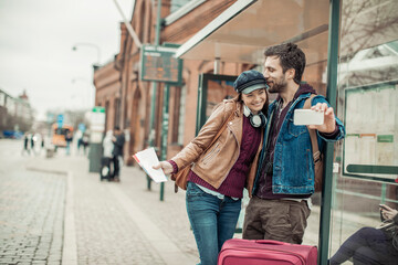 Young caucasian couple traveling and waiting for their bus at the bus station