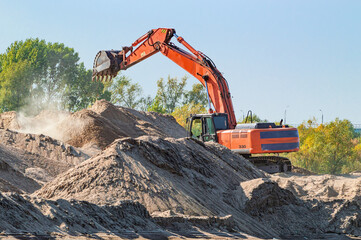 Excavator Digs a Sand on a Sunny Evening