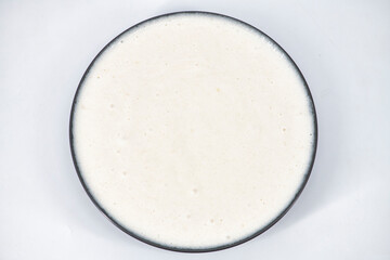 Selective focused image of fermented batter for idli and dosa in an isolated background. Idly and...