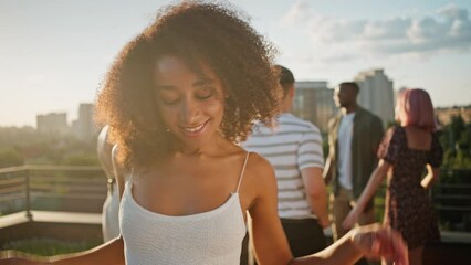 Diverse people drinking, talking and dancing on rooftop - Powered by Adobe