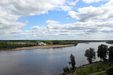 Beautiful view of a flowing river in summer with trees and fields.	