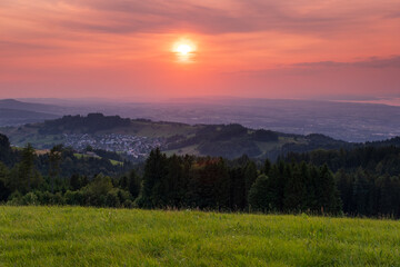 Obraz premium Sonnenuntergang mit Weitblick über grüne Hügel
