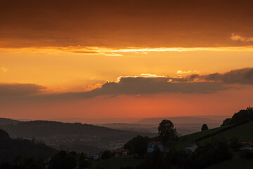 Sonnenuntergang mit Weitblick über grüne Hügel