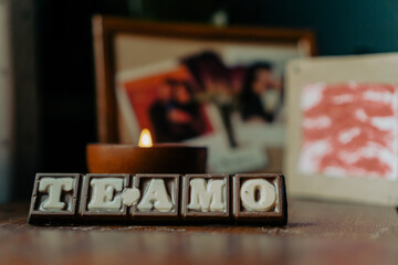 chocolate letters that say "I love you" with photos of a couple in the background