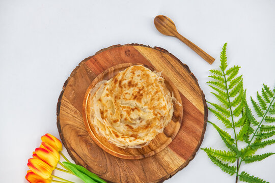Malabar parota in an isolated background. South Indian Porata in a wooden plate and decorated and isolated. Also called nool porata, Roti Parata or Roti