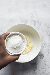 A bowl of white sugar, top view of granulated sugar in a white bowl