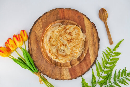Malabar parota in an isolated background. South Indian Porata in a wooden plate and decorated and isolated. Also called nool porata, Roti Parata or Roti&nbsp;, eaten as breakfast and dinner with curry..