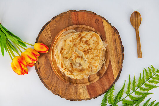 Malabar parota in an isolated background. South Indian Porata in a wooden plate and decorated and isolated. Also called nool porata, Roti Parata or Roti.