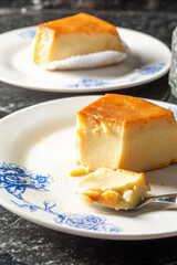 pudim or pudding and a spoon, gourmet homemade dessert. traditional brazilian food known also as flan. vertical shot