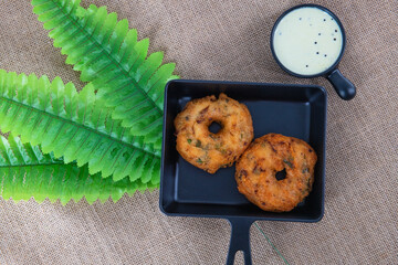 .Indian traditional snacks medhu vadai also called ulunda vadai. Famous Tamilnadu snack called medhu vada in a plate, served with coconut chutney..South Indian tea time snack...