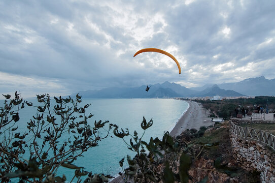 Paragliding on the beach, leisure activity. Beautiful view of Antalya city with mountains and sea bay. Turkey.