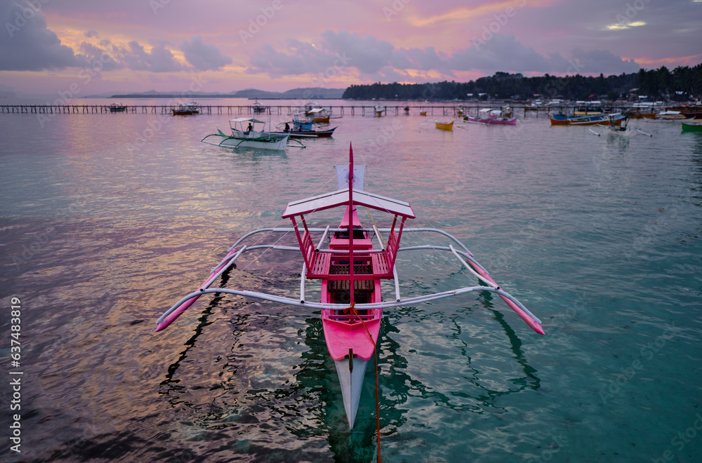 Wall mural beautiful colorful sunset on the seashore with fishing boats. philippines, siargao island.