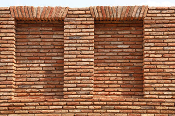background of two 2 Red Brick Windows. bricked frames. front view. blue sky above.  Tbilisi, Georgia.