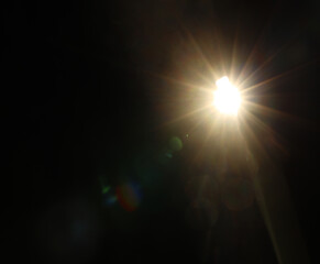 Star With Lens Flare. shiny sun, sunbeams, sunrays, sunshine design. Yellow warm light effect, sun rays, golden beams isolated on black background. star dust