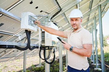 Man adjusting electric switchboard according to instuctions. Male worker checking if switchers...