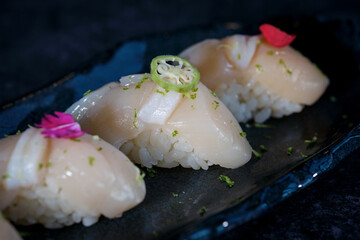 Delicious nigiri sushi with flowers on marble plate
