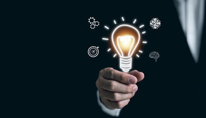 Innovation. Businessman holding light bulb, new idea with innovation and inspiration, creativity. To aim for business goals and success.
