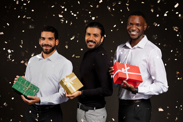 Happy multiethnic handsone young guys holding xmas present boxes