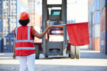 worker or engineer holding red flag in front of crane car in containers warehouse storage
