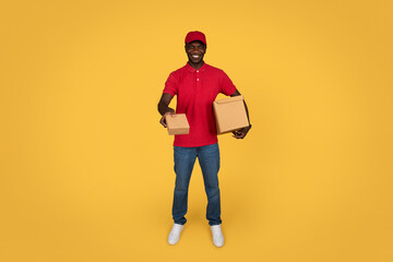 Glad millennial african american guy courier in uniform gives box, deliveryman enjoy work
