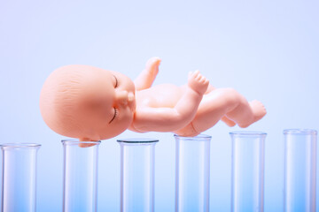Figurine of a pupa on chemical test tubes. Concept of artificial insemination, test tube baby