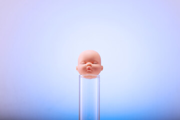 Figurine of a pupa on chemical test tubes. Concept of artificial insemination, test tube baby