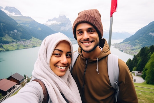 Happy couple taking a selfie with a camera in the Swiss Alps.