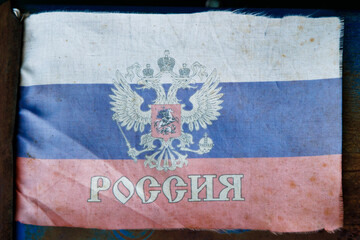 extremely faded small fabric russian flag with with coat of arms