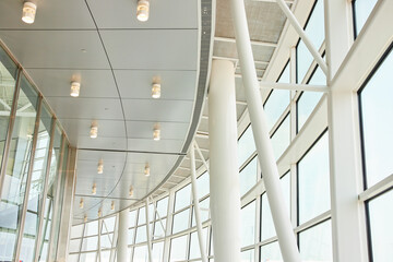 Obraz premium Abstract view of white ceiling architecture and pillars with windows leading to blown out sky