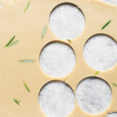 Top view of cutting out rosemary sugar cookie dough, herb cookie dough being cut out, process of making sugar cookies