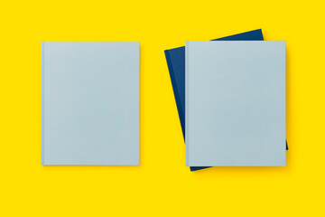 Blank cover blue books on yellow background, mockup