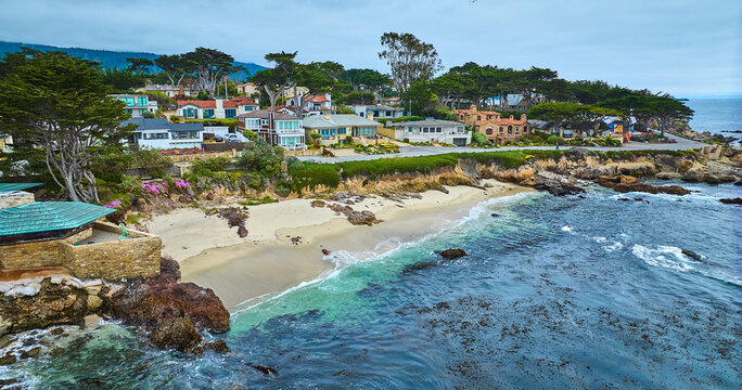 Aerial with edge of Clinton Walker House by Frank Lloyd Wright and Carmel Beach with houses