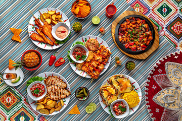 Traditional mexican food. Assortment of chicken dishes: chicken fillet on skewers, barbecue, grill fillet, fachitas. Colorful Food Table Celebration Delicious Party Meal Concept. 