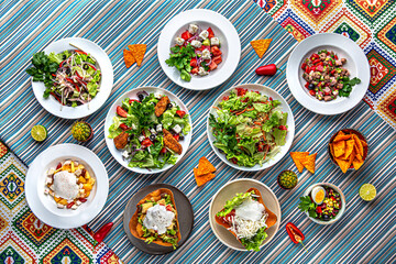 Traditional mexican food. Assortment of salads from vegetables, corn, meat and fruits. Colorful Food Table Celebration Delicious Party Meal Concept. 