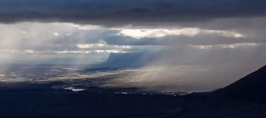 Dramatic Icelandic landscape. Skaftafell National Park in Iceland. Green cliffs, streams and black lava fields.