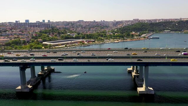 4K aerial shooting of Golden Horn of Istanbul. Drone zooming out from Atat&uuml;rk Bridge over Golden Horn in sunny daylight against Ey&uuml;p stock video.