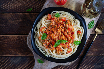 Spaghetti pasta and tomato sauce with chicken mince on a wooden background. Pasta bolognese. Top view