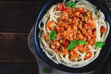 Spaghetti pasta and tomato sauce with chicken mince on a wooden background. Pasta bolognese. Top view