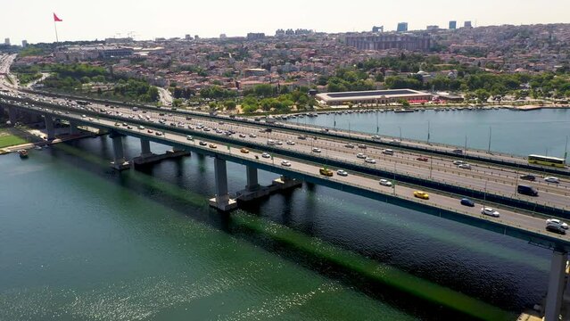 4K aerial shooting of Golden Horn of Istanbul. Drone zooming out from Atat&uuml;rk Bridge over Golden Horn in sunny daylight against Ey&uuml;p stock video.