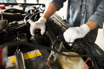 Fototapeta na wymiar Hands of mechanic changing motor oil in car of client