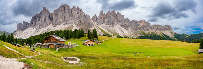 Dolomite landscape in Puez Odle Nature Park - view from alpine plateau with wooden houses and green meadows