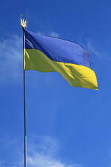 Ukrainian flag on the flagpole. A blue-yellow flag, consisting of two colors. The national two-color flag that is a symbol of Ukraine. Canvas of the national flag of Ukraine, fluttering in the wind