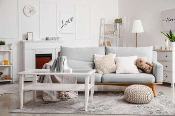 Interior of living room with sofa and stylish holder for books on coffee table