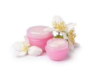 Jars of cosmetic products and beautiful jasmine flowers on white background
