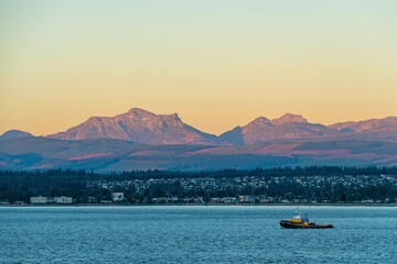Campbell River skyline at sunrise seen from Quadra Island with Vancouver Island mountain ranges in...