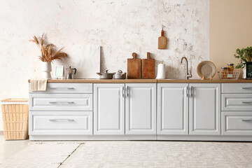 White counters with utensils and sink in modern kitchen