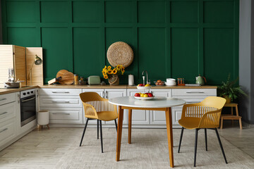 Interior of modern kitchen with white counters and dining table