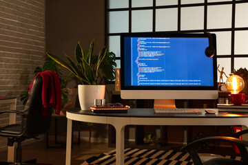Programmer's workplace with computer in dark office