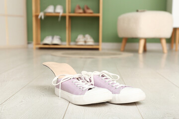 Stylish gumshoes with orthopedic insoles on floor in room
