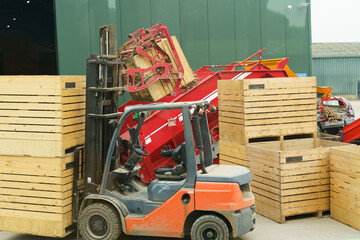 A loader unloads potatoes into a container for subsequent feeding onto a conveyor belt